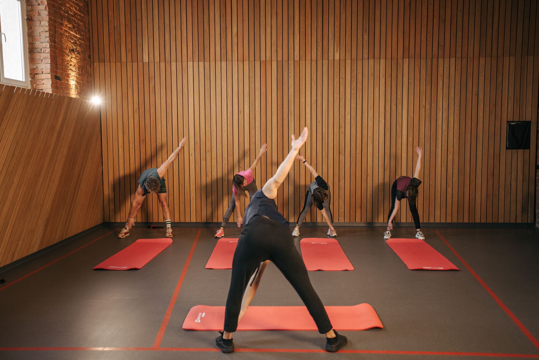 group of people stretching in yoga studio