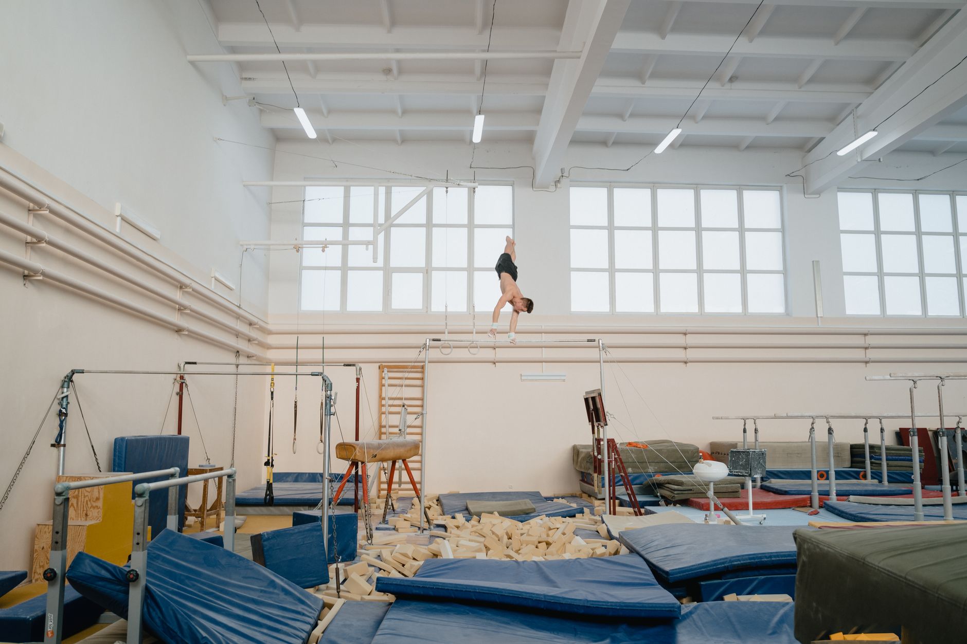 a man doing gymnastics on a parallel bar
