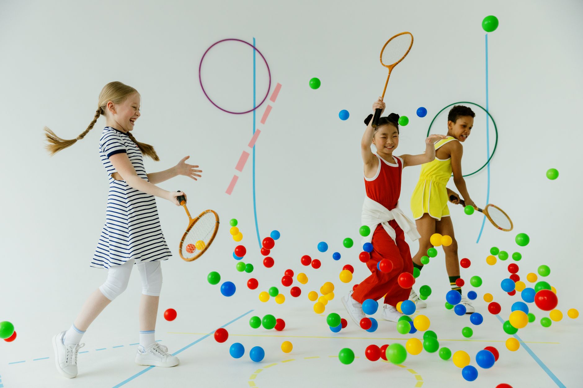 girls having fun while holding tennis rackets