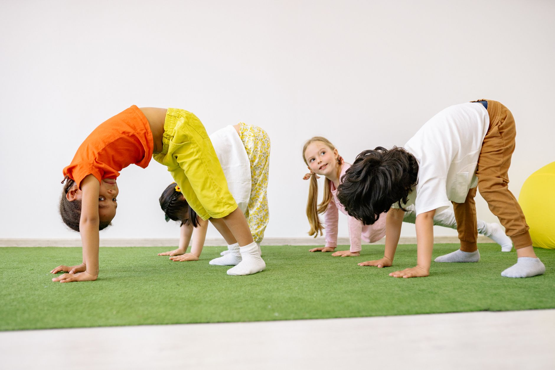 children doing forward bend exercise in school